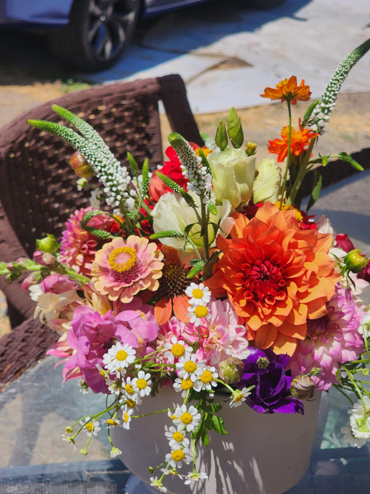 a beautiful arrangement of flowers sitting on a sunny table